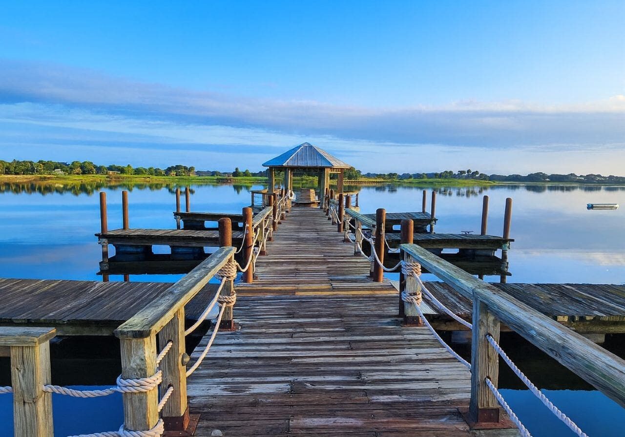 Wooden dock extending into calm blue lake.